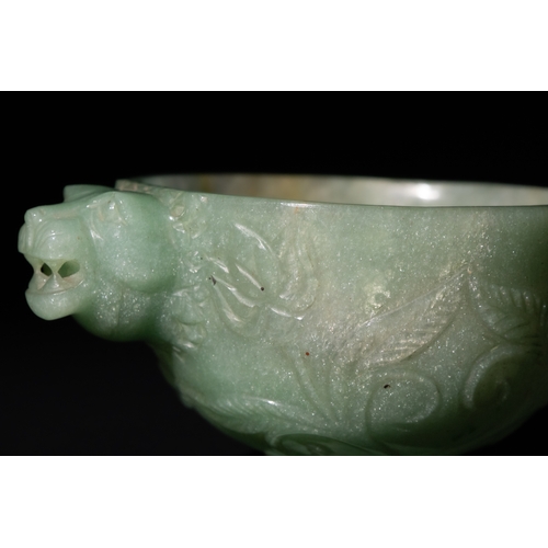 158 - A Mughal-Style Green Jade Bowl with Lion-Head Handle.

The bowl is adorned with floral motifs delica... 