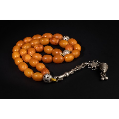 95 - An Islamic Amber Prayer Beads with Silver Tassels.

This set of prayer beads features smooth amber-c... 