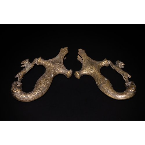 162 - A Pair of Indian Brass Sword Handles with Animal Motif and Floral Engravings.

The handles of this I... 