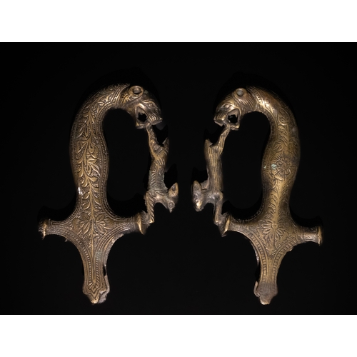 162 - A Pair of Indian Brass Sword Handles with Animal Motif and Floral Engravings.

The handles of this I... 