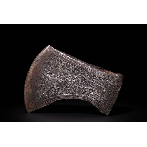 96 - An Islamic Indo-Persian Engraved Iron Axe Head with Calligraphy and Floral Motifs.

The axe head is ... 