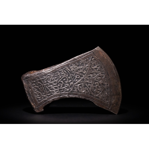 96 - An Islamic Indo-Persian Engraved Iron Axe Head with Calligraphy and Floral Motifs.

The axe head is ... 