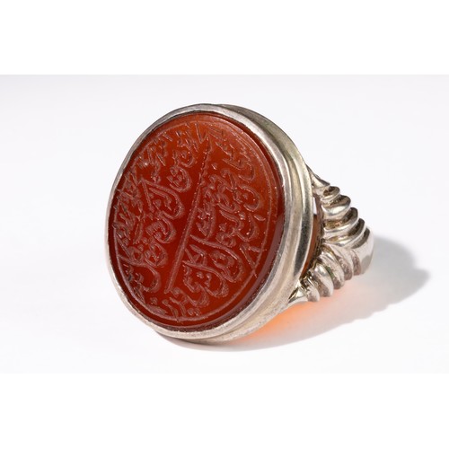 326 - **NO RESERVE**

An Islamic Agate Silver Ring with Calligraphic Inscription.

 ring features a deep r... 