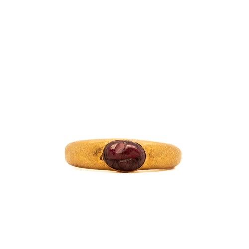 14 - A Roman Gold Hollow Ring with Garnet Cabochon.

This ring features a smooth, oval garnet gemstone se... 