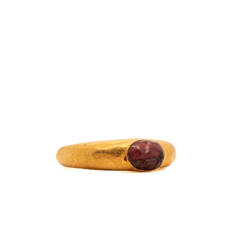 14 - A Roman Gold Hollow Ring with Garnet Cabochon.

This ring features a smooth, oval garnet gemstone se... 