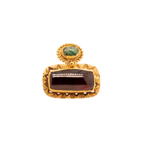 41 - A Byzantine Gold Ring with Garnet and Emerald.

A Byzantine gold ring featuring an oval garnet gemst... 