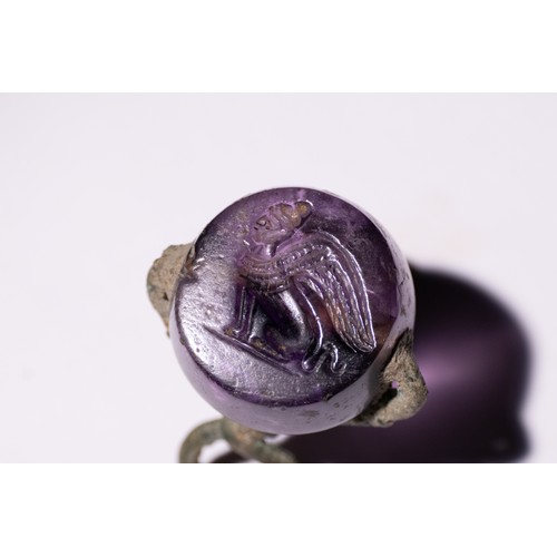 62 - A Roman Amethyst Intaglio Seal with Winged Figure.

A Roman amethyst stamp pendant, showcasing a tra... 