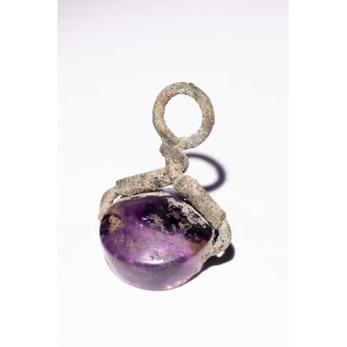 62 - A Roman Amethyst Intaglio Seal with Winged Figure.

A Roman amethyst stamp pendant, showcasing a tra... 