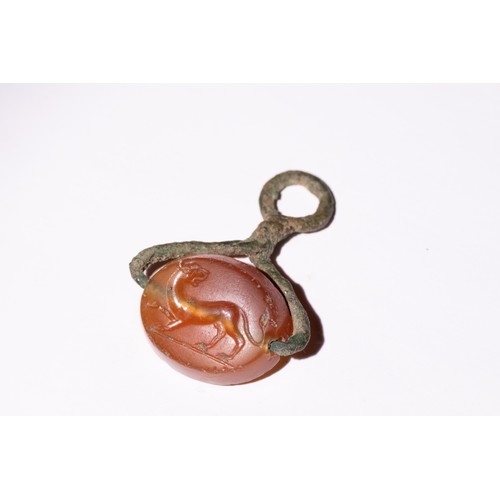 63 - A Hellenistic Agate and Bronze Intaglio Seal with Lion Motif.

An oval-shaped agate intaglio seal fe... 