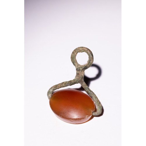 63 - A Hellenistic Agate and Bronze Intaglio Seal with Lion Motif.

An oval-shaped agate intaglio seal fe... 