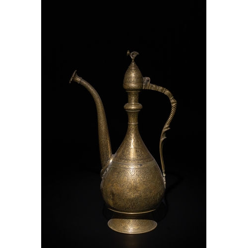 110 - An Islamic Qajar Brass Ewer with Intricate Floral Engravings, 19th Century.

This Qajar brass ewer f... 