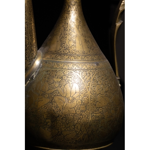 110 - An Islamic Qajar Brass Ewer with Intricate Floral Engravings, 19th Century.

This Qajar brass ewer f... 