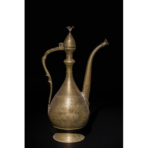 110 - An Islamic Qajar Brass Ewer with Intricate Floral Engravings, 19th Century.

This Qajar brass ewer f... 