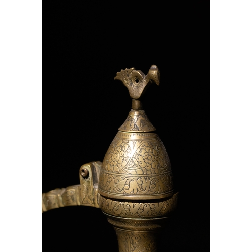 110 - An Islamic Qajar Brass Ewer with Intricate Floral Engravings, 19th Century.

This Qajar brass ewer f... 