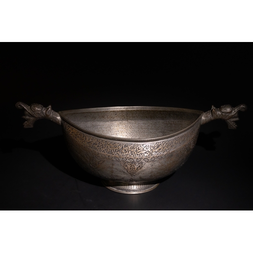 115 - A Persian Tinned-Copper Kashkul with Dragon Handles, 17th Century.

A tinned-copper vessel featuring... 