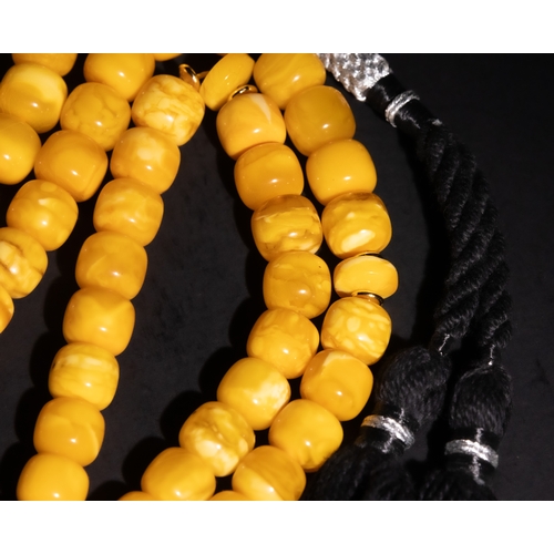 126 - An Islamic Amber Prayer Beads Tasbih with Black Tassel.

Each bead is smoothly rounded, contributing... 