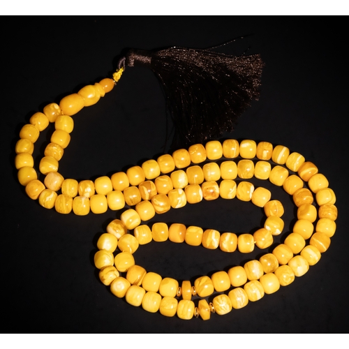 127 - An Islamic Amber Prayer Beads Tasbih with Black Tassel.

Each bead is smoothly rounded, contributing... 