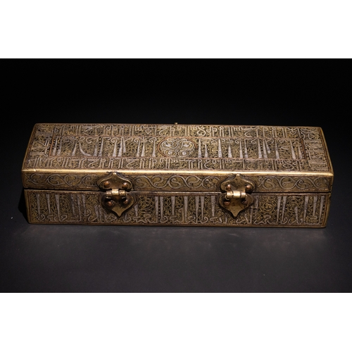 144 - An Islamic Khurasan Style Silver-Inlaid Brass Pen-Case.

A rectangular brass pen-case adorned with i... 