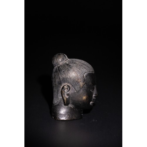 83 - A Chinese Bronze Head of a Possible Buddhist Deity. 

A bronze head depicting a serene face with sof... 