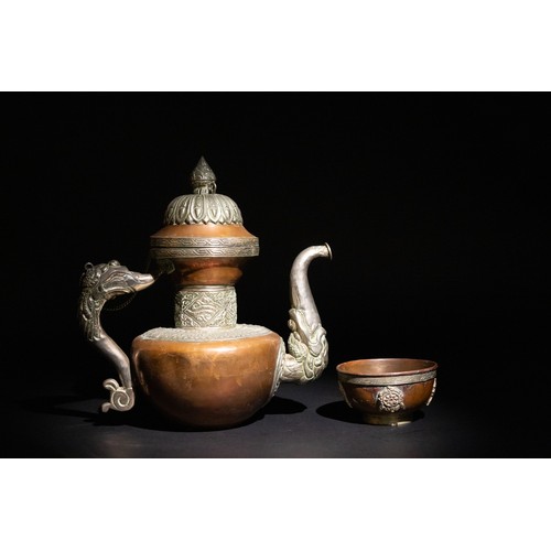 319 - **NO RESERVE**

A Tibetan Silver and Copper Dragon-Handled Tea Pot with Cup.

An ornamented Tibetan ... 