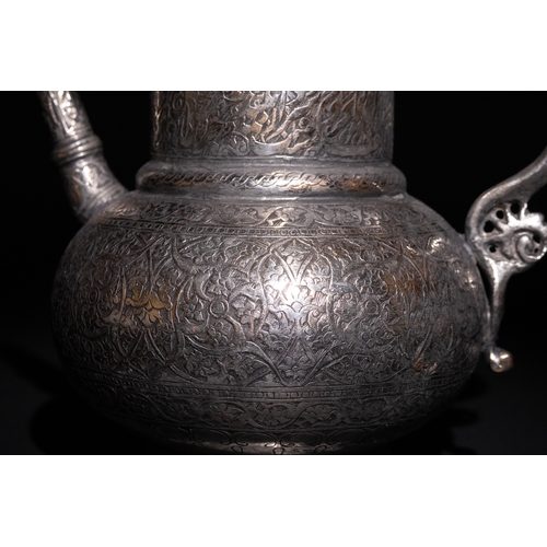 19 - An Islamic Timurid Copper Ewer with Engraved Calligraphy and Dragon Handle.

A copper ewer featuring... 