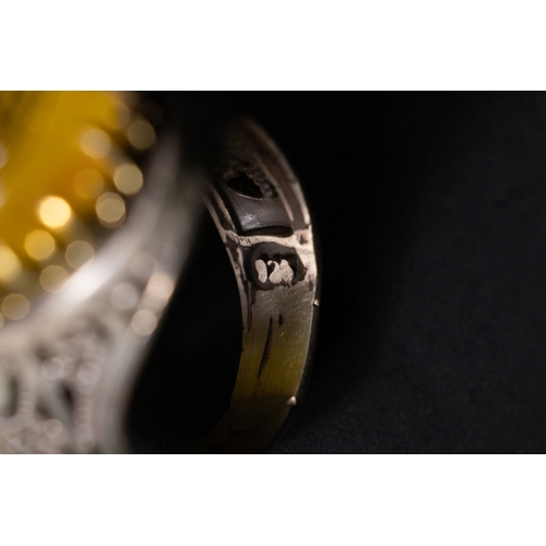 56 - An Islamic Silver Ring with Inscribed Yellow Agate.

A silver ring featuring a rounded oval yellow a... 