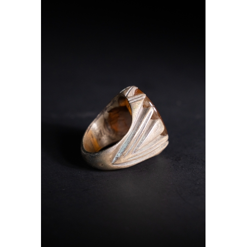57 - An Islamic Silver Ring with Inscribed Amber-Toned Agate.

A silver ring set with an oval agate stone... 