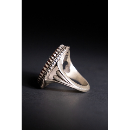 59 - An Islamic Silver Ring with Inscribed Orange Agate.

A silver ring featuring an oval orange agate st... 