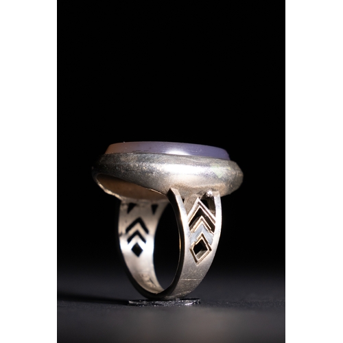 61 - An Islamic Silver Ring with Inscribed Lavender Agate.

A silver ring featuring an oval lavender agat... 