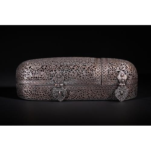 A Safavid Openwork Copper Qalamdan Pen Box with Qur’anic Inscriptions, 17th Century.

An elongated Safavid copper pen box, finely worked in openwork with interlacing arabesques and dense floral scrolls. The hinged domed lid is pierced with a geometric floral lattice design, while the sides bear meticulously engraved and pierced Qur’anic inscriptions in elegant naskh script. The front is fitted with two floral-shaped clasps, each detailed with pierced arabesque work. The interior reveals compartments for writing instruments, with a fitted tray and three domed inkwell covers decorated with engraved vegetal motifs.

Approximately 9 x 28 x 8cm (hxlxw)

Provenance: Private collection from a distinguished W London collector.