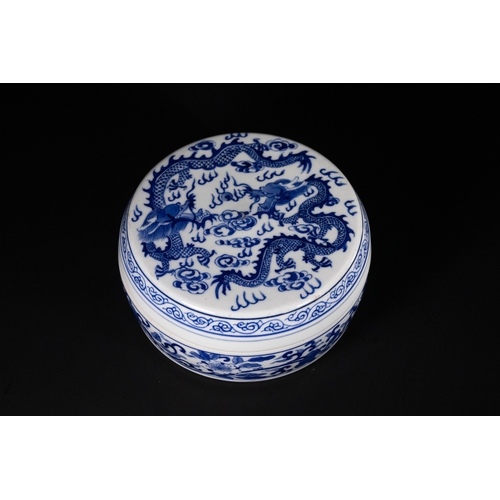 369 - A Chinese Blue and White Lidded Porcelain Box with Dragon and Phoenix Motifs. 
The rounded porcelain... 