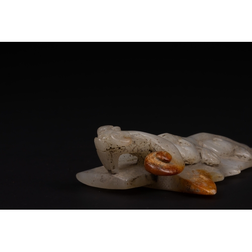 396 - A Chinese Carved Jade Belt Hook with Dragon Motif.

Carved from pale grey jade with areas of warm ru... 