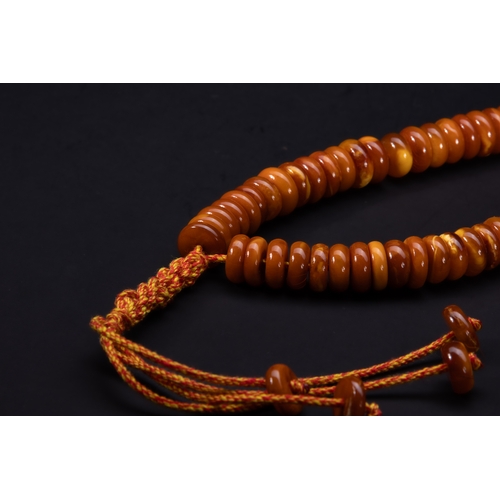 184 - An Islamic Butterscotch Amber Bead Strand.

A strand composed of rounded, flattened butterscotch amb... 