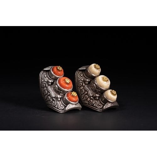 261 - A Pair of Tibetan White Metal Rings Set with Cabochons.

A matched pair of Tibetan white metal rings... 