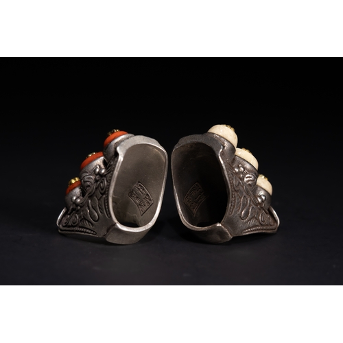 261 - A Pair of Tibetan White Metal Rings Set with Cabochons.

A matched pair of Tibetan white metal rings... 