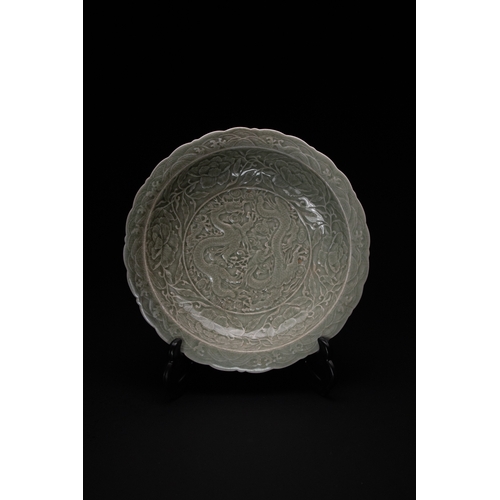 448 - A Chinese Celadon-Glazed Carved ‘Dragon and Peony’ Dish.

A celadon-glazed dish with a scalloped rim... 