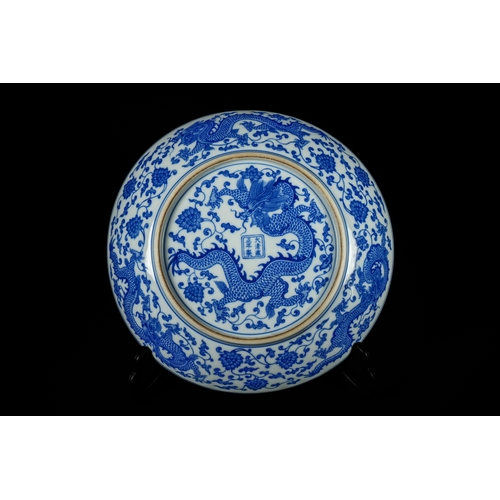 318 - A Chinese Blue and White 'Dragon' Dish, Kangxi Mark. - A circular Chinese blue and white porcelain d... 