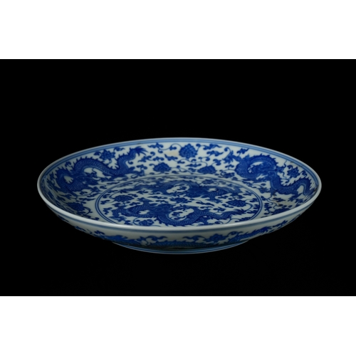 318 - A Chinese Blue and White 'Dragon' Dish, Kangxi Mark. - A circular Chinese blue and white porcelain d... 