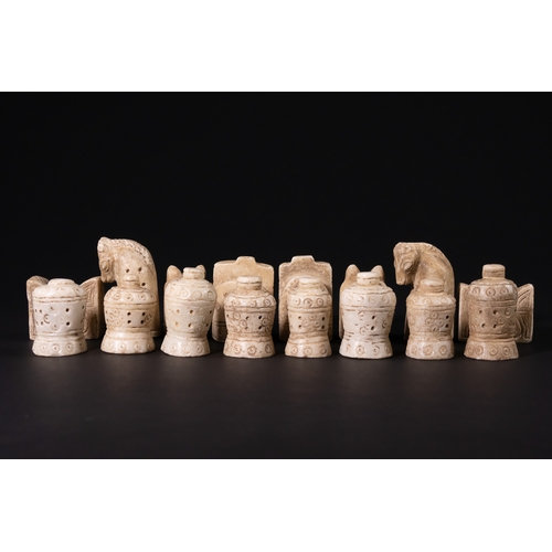31 - A Complete Stone Half Chess Set, 19th Century.

A complete carved stone half chess set comprising si... 