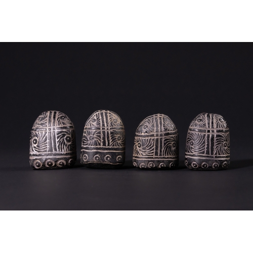 32 - A Group of Four Black Glass Gaming Pieces with Incised White Decoration, 19th Century.

A group of f... 