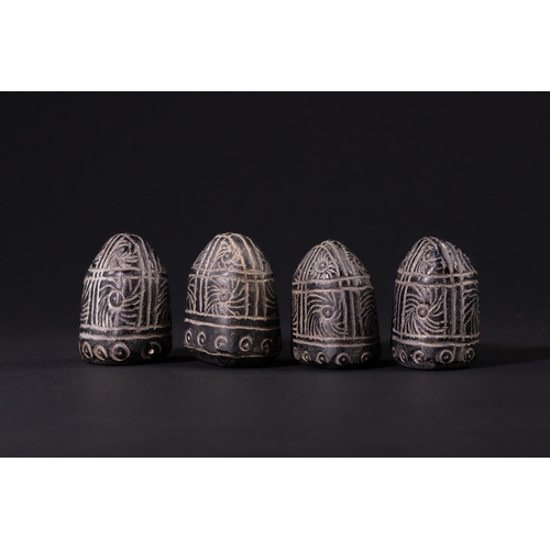 32 - A Group of Four Black Glass Gaming Pieces with Incised White Decoration, 19th Century.

A group of f... 