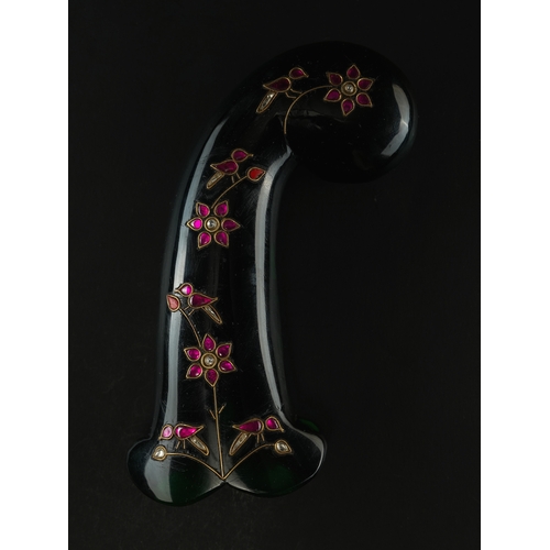 85 - A Mughal Glass Hilt with Floral Decoration.

Of curved form, the hilt fashioned from deep green glas... 