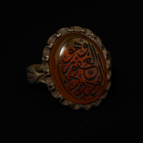 205 - An Islamic Silver Ring Set with an Oval Carved Agate Seal Stone.

An Islamic silver-mounted seal rin... 