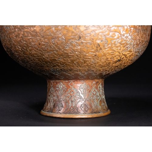 12 - An Islamic Copper Ewer with Incised Scrollwork, 19th Century.

An Islamic copper ewer featuring a bu... 