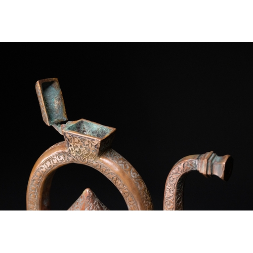 12 - An Islamic Copper Ewer with Incised Scrollwork, 19th Century.

An Islamic copper ewer featuring a bu... 