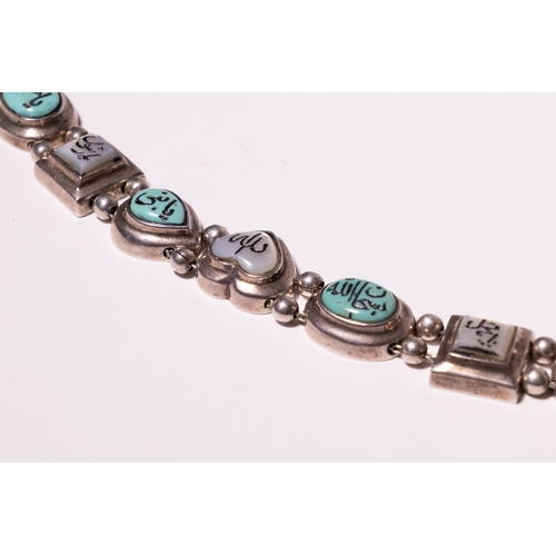 21 - A Middle Eastern Silver and Turquoise Inset Bracelet with Arabic Inscriptions.

A decorative silver ... 