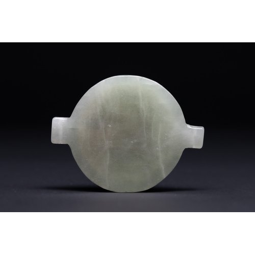 30 - An Islamic Jade Bazuband Amulet with Brass Talismanic Inscription Panel.

A circular bazuband-form a... 