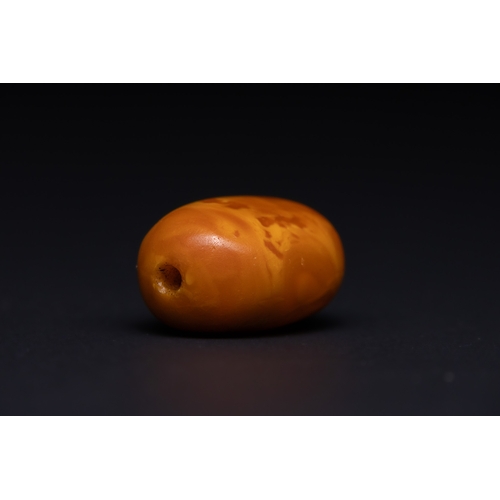 32 - A Butterscotch Amber Barrel Bead with Natural Inclusions.

A single rounded barrel-form amber bead o... 