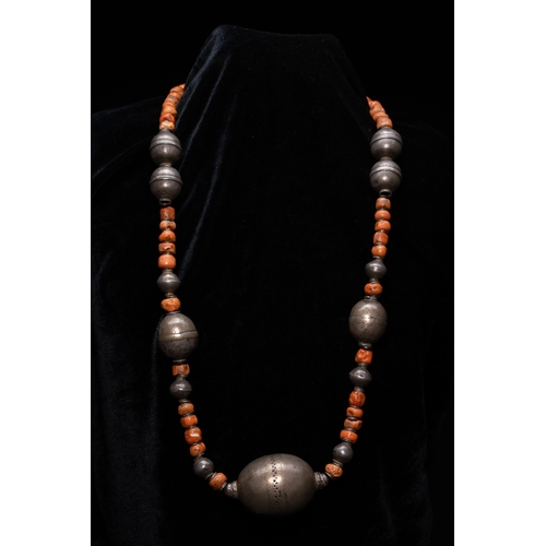 56 - A Turkmen Tribal Silver and Coral Bead Necklace.

The necklace is formed from a strand of irregular ... 