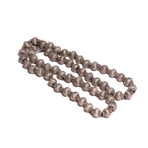 60 - A Tribal White Metal Bead Necklace.

The necklace is composed of a continuous strand of large, hollo... 